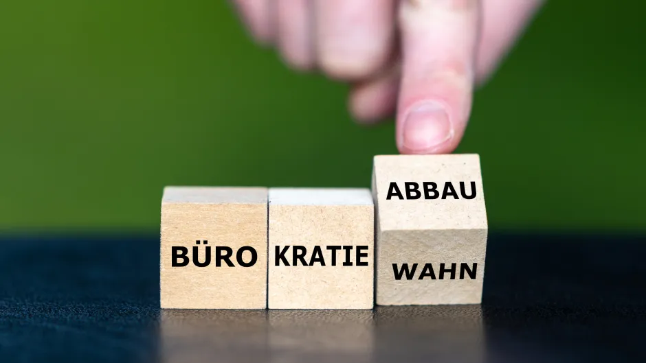 Drei Würfel mit der Aufschrift Bürokratie/Wahn/Abbau